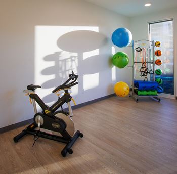 a gym with an exercise bike and balloons on the wall